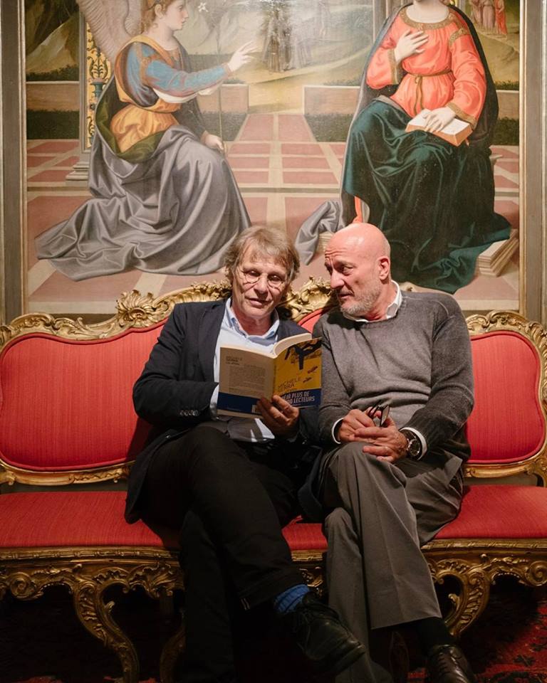 Claudio Bisio e Daniel Pennac ospiti di Inge Feltrinelli mentre sfogliano la versione francese de Gli Sdraiati di Michele Serra